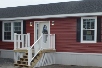 A manufactured home under 1000 square feet A photo of a red single wide manufactured home