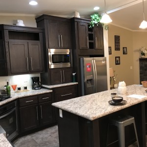 Modular and manufactured home kitchen island with granite countertop and wood cabinets