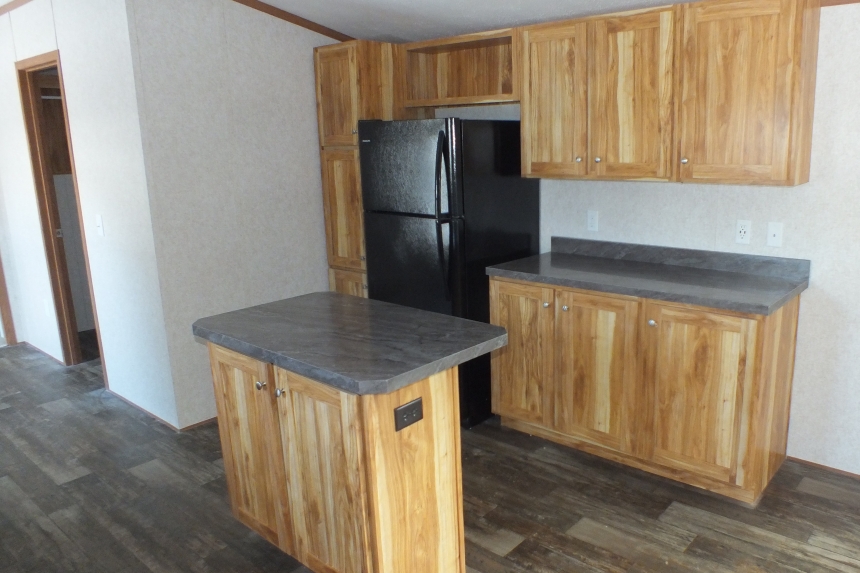Single wide home in Milton Vermont kitchen with refrigerator A Photo Of 141 Milton Vermont Single Wide Home Kitchen With Island And Black Refrigerator.