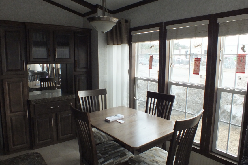 The Park Model 7 manufactured home dining area A Photo Of Park Model 8 Manufactured Home Dining Area With Able In Front Of Large Bright Windows.