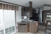 The Park Model 7 manufactured home furnished living area A Photo Of Park Model 8 Manufactured Home Furnished Living Area With Sliding Glass Door Looking Into Kitchen.