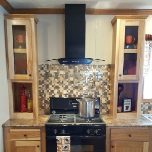 Modular and manufactured home kitchen black stove and hood with tile splash back