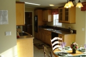 Double Wide home 5228-405-1 dining area Photo Of Double Wide Home 5228-405-1 Dining Area With Small Table Looking Into Kitchen With Wood Cabinets