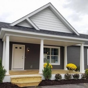 Photo of manufactured home gray exterior with porch and yellow flowers