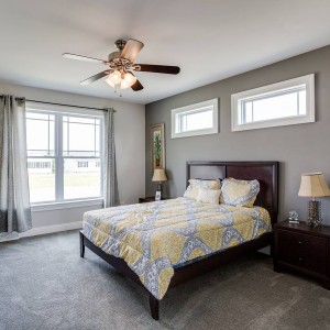 Photo of manufactured home interior furnished bedroom with bed ceiling fan and chest of drawers