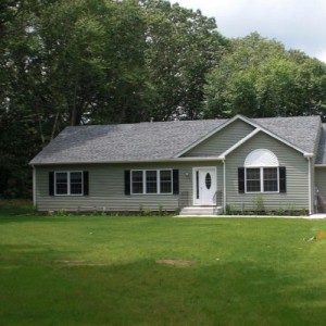 Photo of manufactured home green exterior with lawn with lawn driveway and garage