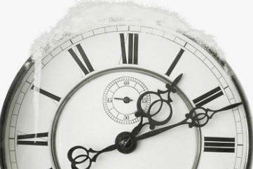 A photo of a old fashioned clock covered in snow.