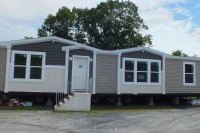 A photo of a beige double-wide manufactured home.