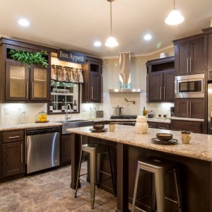 Modular and manufactured home kitchen with island wood cabinets and bright recessed lighting